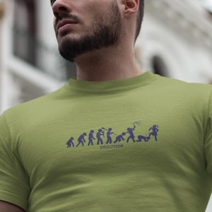 May include: Olive green t-shirt featuring a blue graphic of human evolution. The word "EVOLUTION" is printed below the figures. The shirt is made of a soft material and has short sleeves.