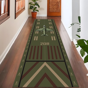 Peut inclure: Tapis de couloir vert avec un motif de piste d'aéroport et un avion. Le tapis affiche le texte "20R" et des marquages directionnels. Les couleurs sont le vert, le marron et le beige, idéal pour un couloir.