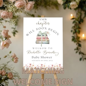 Pu&ograve; includere: Un cartello di benvenuto bianco con una pila di libri legati con un nastro e fiori. Il cartello recita "A new chapter will soon begin. Welkom to Rachelle Beaudry Baby Shower. Saturday 08 April 20XX".
