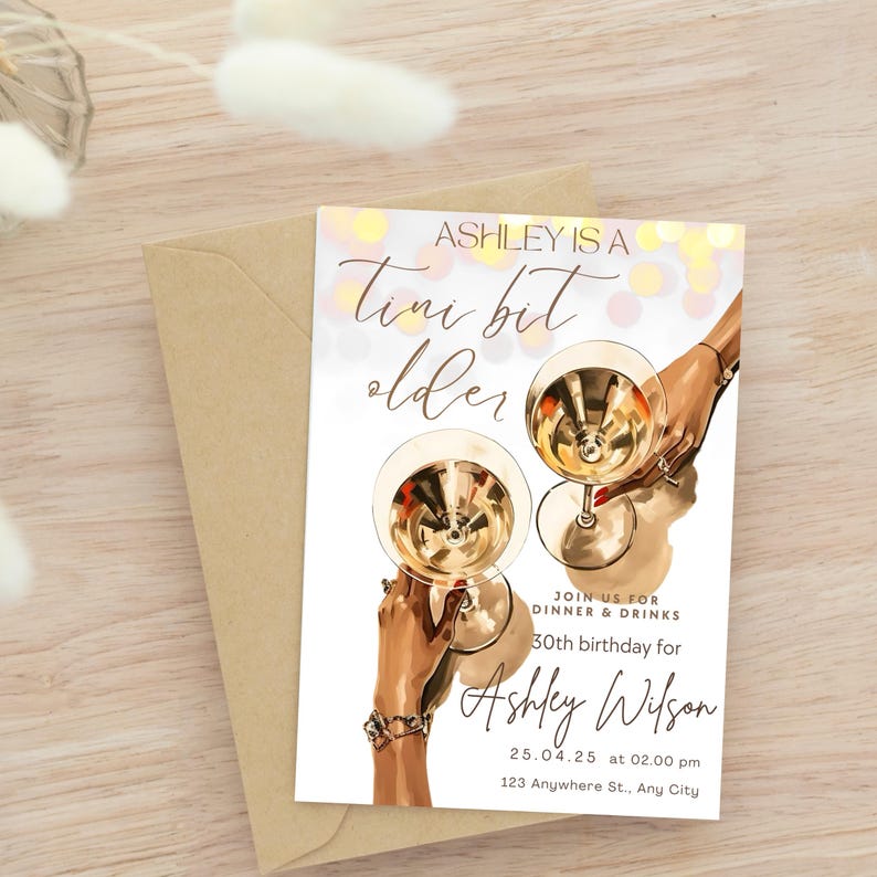 May include: A white invitation card with gold text and a graphic of two hands holding champagne flutes. The text reads "Ashley is a tiny bit older" and includes details for a 30th birthday party.