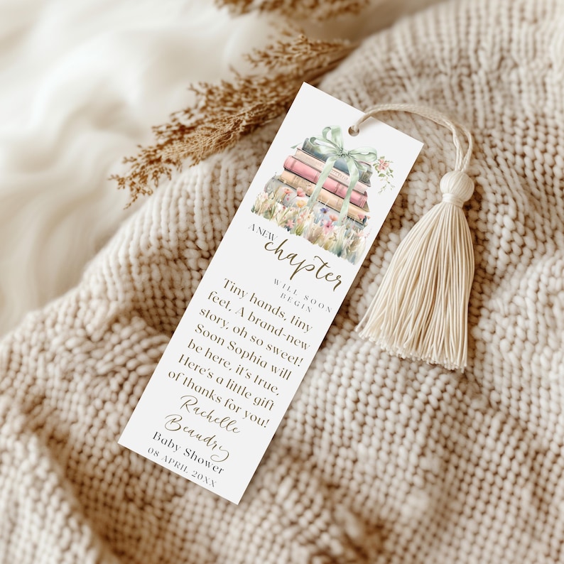 Pu&ograve; includere: Un segnalibro bianco con un'illustrazione ad acquerello di una pila di libri con fiori e un nastro verde. Il testo sul segnalibro recita "A new chapter will soon begin. Tiny hands, tiny feet. A brand-new story, oh so sweet! Soon Sophia will be here, it's true. Here's a little gift of thanks for you! Rachelle Beandry Baby Shower 08 APRIL 20XX"