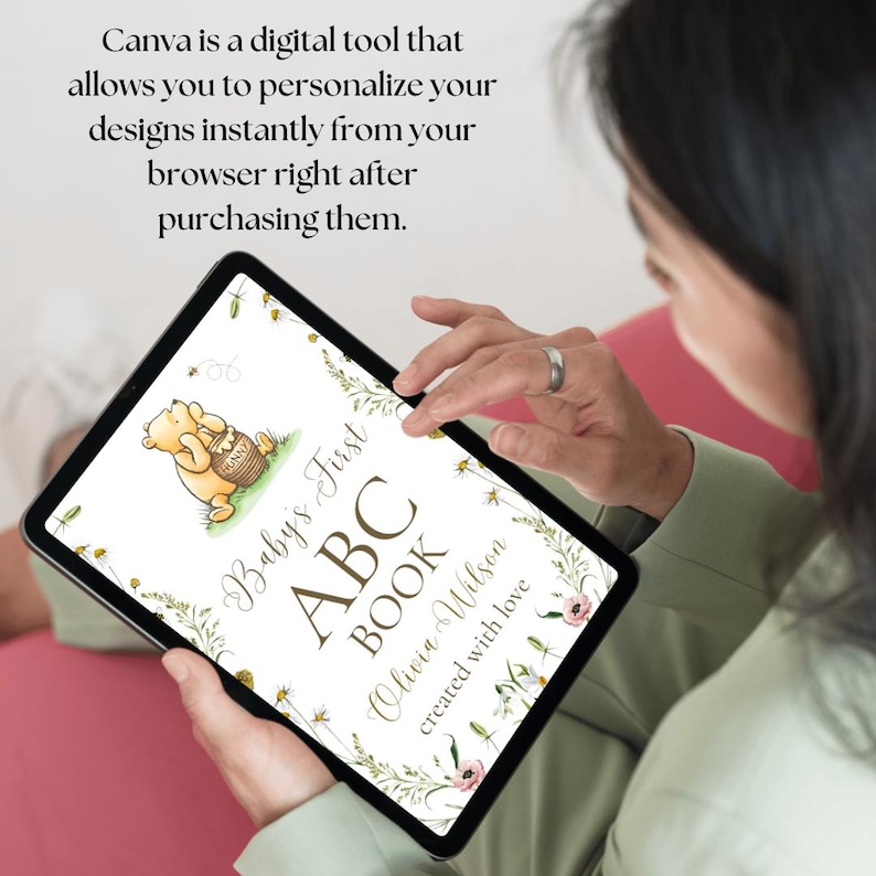K&ouml;nnte beinhalten: Ein digitales Tablet zeigt ein personalisiertes erstes ABC-Buch f&uuml;r Babys mit einer Illustration von Winnie Puuh. Der Buchumschlag zeigt ein Blumenmuster und den Text "Baby's First ABC Book Olivia Wilson created with love."