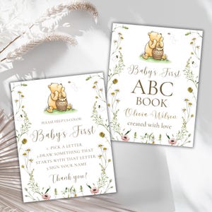 K&ouml;nnte beinhalten: Zwei druckbare Karten mit Winnie Puuh und einem Honigtopf. Die erste Karte sagt "Baby's First ABC Book Olivia Wilson created with love". Die zweite Karte sagt "Bitte hilf uns beim Ausmalen Baby's First 1. W&auml;hle einen Buchstaben 2. Zeichne etwas, das mit diesem Buchstaben beginnt 3. Unterschreibe deinen Namen Danke!"