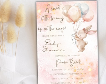 Pode incluir: Um convite de chá de bebê rosa e branco com um coelho fofo segurando balões. O texto diz "A sweet little bunny is on the way!" e "Baby Shower". O convite também inclui o nome "Paula Black", a data e hora do chá de bebê, e o endereço. As informações de RSVP também estão incluídas.