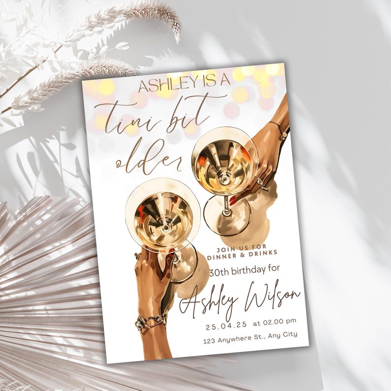 May include: A white invitation card with a gold and pink background. The text reads "Ashley is a Tini bit older" and includes details for a 30th birthday party. The card features a hand holding a martini glass.