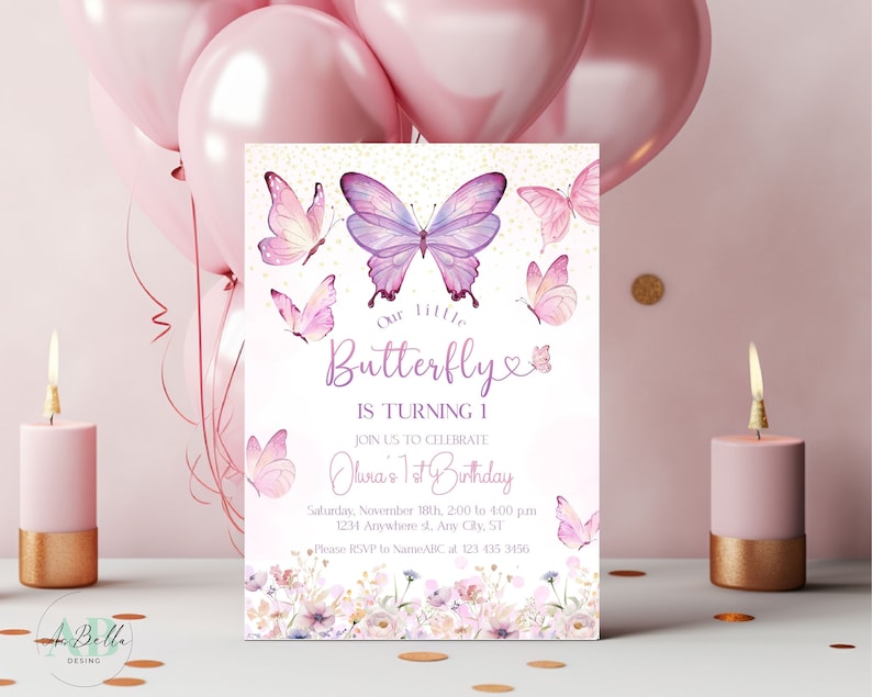 May include: A pink and purple butterfly-themed first birthday party invitation with gold glitter accents. The invitation features a large purple butterfly with pink accents and smaller butterflies in pink and white. The text reads "Our little Butterfly is turning 1. Join us to celebrate Olivia's 1st Birthday. Saturday, November 18th, 2:00 to 4:00 pm. 1234 Anywhere st. Any City, ST. Please RSVP to NameABC at 123 435 3456."