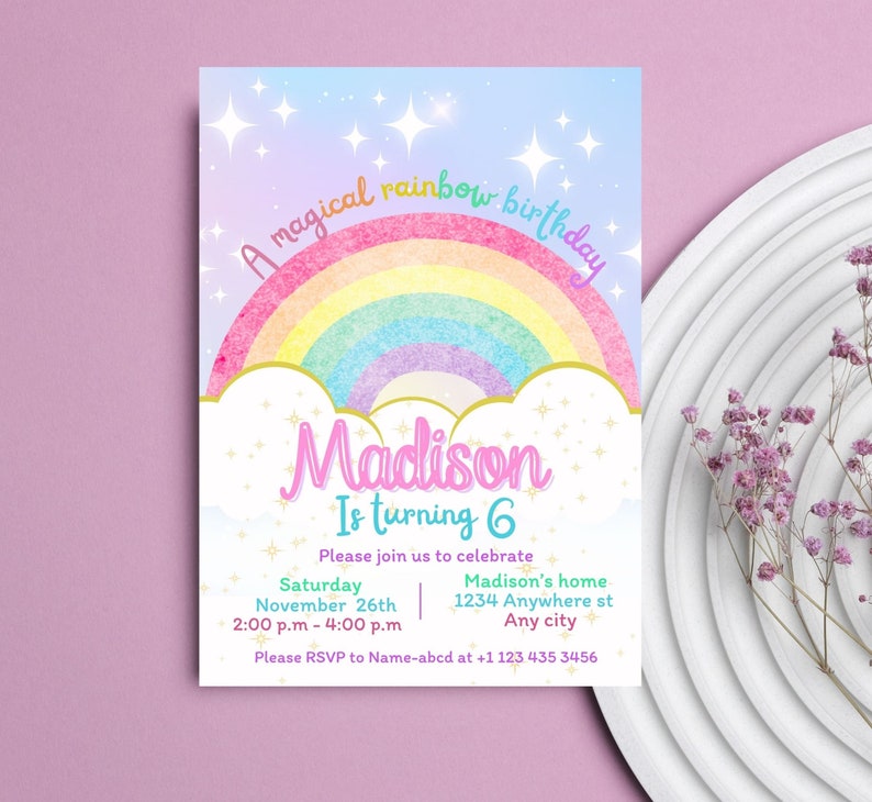May include: A colorful rainbow birthday invitation with a watercolor effect. The invitation features a rainbow with a gold outline, clouds, and sparkling stars. The text "A magical rainbow birthday" is written in a whimsical font. The name "Madison" is written in a pink font with a gold outline. The text "Is turning 6" is written in a blue font. The invitation includes details for the birthday party, including the date, time, and location. The text "Please RSVP to Name-abcd at +1 123 435 3456" is written at the bottom of the invitation.