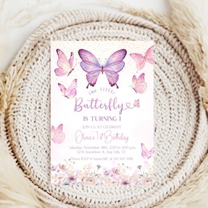 May include: Purple and pink butterfly birthday invitation with a floral border. The text reads "Our little Butterfly is turning 1. Join us to celebrate Olura's 1st Birthday. Saturday, November 18th, 2:00 to 4:00 pm. 1234 Anywhere st, Ary City, ST. Please RSVP to NameABC at 123 435 3456."
