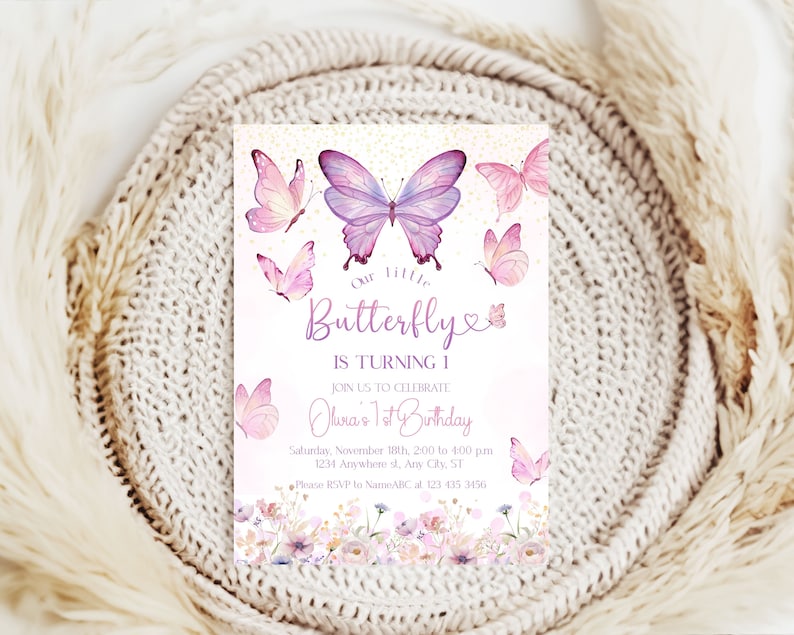 May include: Purple and pink butterfly birthday invitation with a floral border. The text reads "Our little Butterfly is turning 1. Join us to celebrate Olura's 1st Birthday. Saturday, November 18th, 2:00 to 4:00 pm. 1234 Anywhere st, Ary City, ST. Please RSVP to NameABC at 123 435 3456."