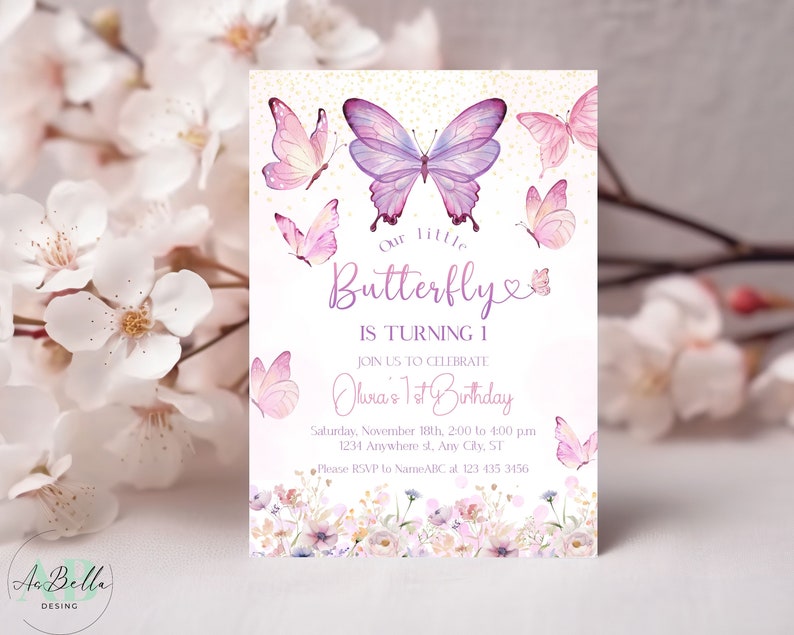 May include: A pink and purple butterfly birthday invitation with gold glitter accents. The invitation says "Our little butterfly is turning 1. Join us to celebrate Olivia's 1st Birthday. Saturday, November 18th, 2:00 to 4:00 pm. 1234 Anywhere st, Any City, ST. Please RSVP to NameABC at 123 435 3456."