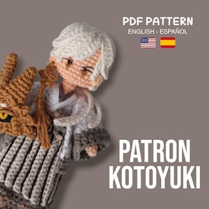 May include: A crocheted doll with a white and gray outfit, holding a brown dragon head. The doll has white hair and a peach-colored face. Text on the image reads "PDF PATTERN ENGLISH - ESPAÑOL" and "PATRON KOTUYUKI".