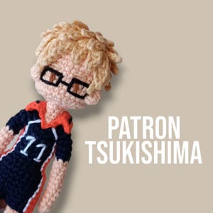 May include: Crocheted amigurumi figure of a character wearing a black and orange volleyball uniform with the number 11 on the front. The character has blonde hair and is wearing glasses. The text "PATRON TSUKISHIMA" is written in white on a beige background.