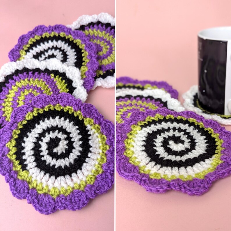 May include: A collection of handmade crochet coasters. Each coaster features a spiral design with black, white, green, and purple yarn. The coasters have a scalloped edge and are arranged on a pink surface.
