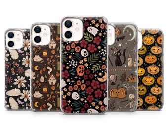 May include: Five clear smartphone cases featuring various Halloween-themed patterns including ghosts, pumpkins, skulls, flowers, black cats, and the text 'spooky season' printed on the back of the cases, arranged in a row against a white background.