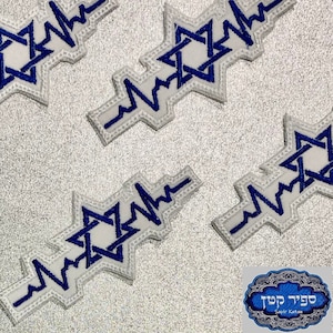 May include: Four white embroidered patches with a blue Star of David and a white EKG line. The patches are on a silver background. The text "Sapir Katan" is visible in the lower right corner.