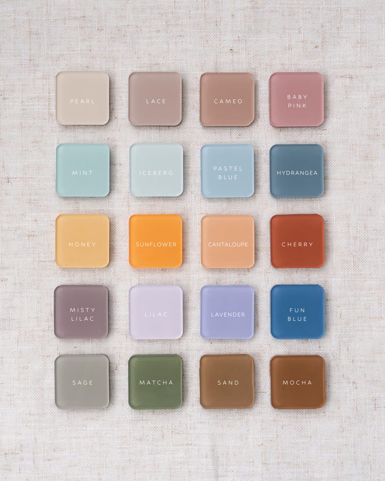 May include: Sixteen square color swatches in various pastel shades, including pearl, mint, and lavender. Each swatch has a color name printed in white. The swatches are arranged in a grid on a neutral linen background.