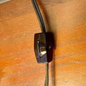 May include: A black electrical cord with an inline on/off switch. The switch is a rotary dial with a black plastic housing.