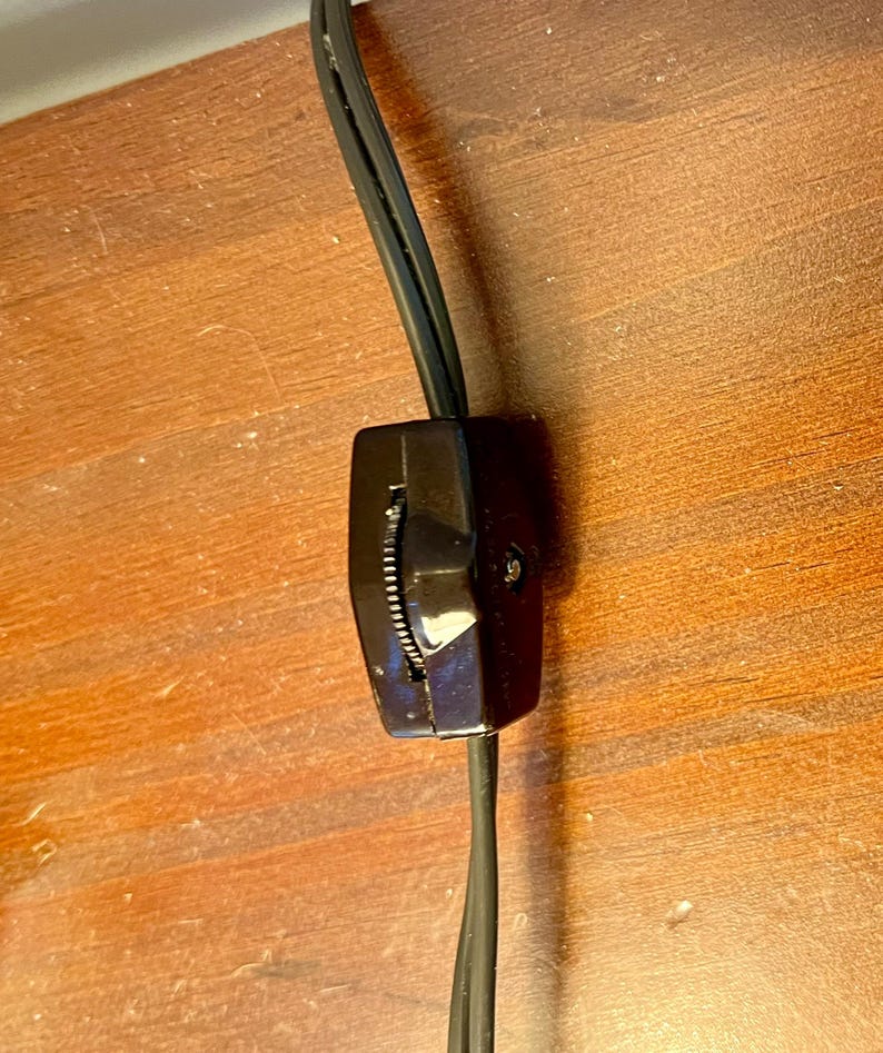 May include: A black electrical cord with an inline on/off switch. The switch is a rotary dial with a black plastic housing.