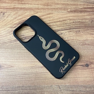 May include: Black phone case with a gold snake design and the name "Rachel Green" written in gold lettering.