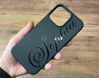 May include: Black phone case with a silver inscription of the name "Sophia" in a cursive font.