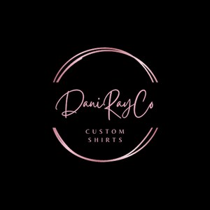 May include: A pink and white logo with the text "Dani Ray Co" in a handwritten font. The text is inside a double circle with a gold outline. The text "CUSTOM SHIRTS" is below the logo.