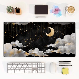 May include: A black and gold desk mat with a crescent moon and stars on a dark blue background. The mat features a watercolor effect with white clouds and gold accents.