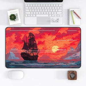 May include: A rectangular gaming mousepad featuring a pirate ship sailing on a sea under a sunset sky. The mousepad has zones labeled "Battlefield", "Lands", "Library", "Graveyard", "Command Zone", "Exile", and "Life".
