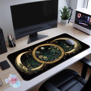 May include: A black and gold mousepad with a design of three overlapping crescent moons with a green and gold floral pattern. The moons are set against a dark green background with white stars.