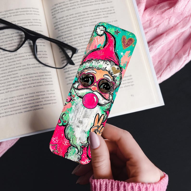 May include: A colorful phone case featuring a cartoon Santa Claus with sunglasses blowing a bubblegum bubble. The case has a pink and teal background with hearts and snowflakes. The Santa is giving a peace sign.