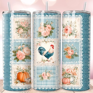 May include: Three tall, insulated tumblers with floral and rooster designs. The tumblers feature a light blue background with white lace trim. Each tumbler has a different arrangement of roses, pumpkins, and a rooster. The tumblers have a silver straw.