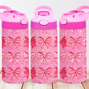 Könnte beinhalten: Drei rosa Wasserflaschen mit einem rosa Glitzerhintergrund und einem rosa Schleifenmuster. Die Flaschen haben einen rosa Deckel mit einem Tragegriff.