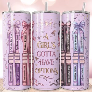 May include: A light purple cylindrical tumbler with a straw, featuring a wrap-around design of stacked books with titles like Celestial Gardens and Sapphire Dreams, tied with ribbons, and the text A GIRL'S GOTTA HAVE OPTIONS in gold lettering.