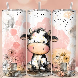 Puede incluir: Un juego de tres vasos de acero inoxidable con tapas y pajitas. Cada vaso presenta un diseño de acuarela de una vaca de dibujos animados con manchas blancas y negras, sentada frente a un fondo rosa y gris con flores.
