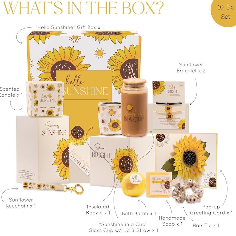 May include: A white gift box with a sunflower design and the text "Hello Sunshine" on the lid. The box contains a variety of items, including a scented candle, a sunflower keychain, a bath bomb, a handmade soap, a pop-up greeting card, a hair tie, a glass cup with a lid and straw, an insulated koozie, and two sunflower bracelets.
