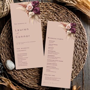 May include: Two wedding ceremony programs with floral decorations. The programs are light pink with text that reads "The Wedding of Lauren and Connor" and "Wedding Party". The programs are decorated with dried flowers and roses.