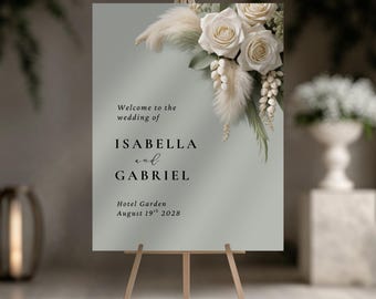 May include: A wedding welcome sign on a wooden easel. The sign is sage green with floral accents and text that reads "Welcome to the wedding of Isabella and Gabriel, Hotel Garden, August 19th 2028."