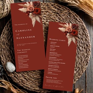 Peut inclure: Un programme de mariage bordeaux avec un motif floral composé de pampas séchées et de roses rouges. Le programme liste l'ordre de la cérémonie de mariage et la fête de mariage.