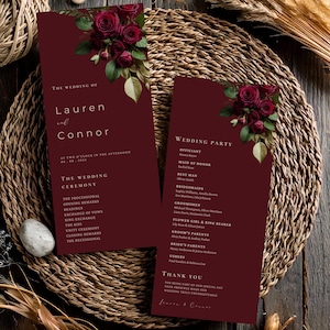 May include: Burgundy wedding ceremony programs with floral accents. The programs feature the names "Lauren and Connor" and wedding details. The design includes a list of the wedding party and ceremony details.