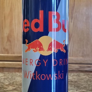 May include: A blue and white 20oz tumbler with a red bull logo and the text "Red Bull Energy Drink Witkowski" and "Vitlizes Body and Mind".