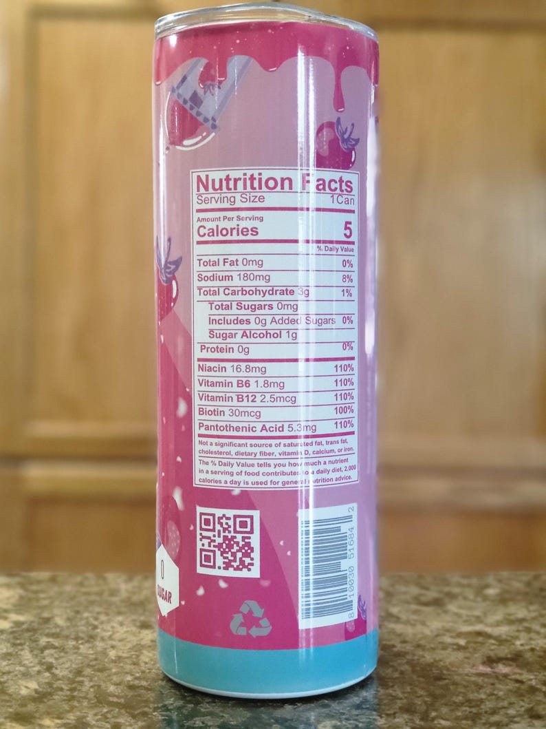 May include: A cylindrical beverage container with a pink and blue design. The container features a nutrition facts label with details on calories, vitamins, and other nutritional information. The design includes a dripping effect and fruit illustrations.