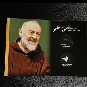 Puede incluir: Una foto de primer plano de un hombre con una túnica marrón. El hombre tiene barba blanca y sonríe. La foto está rodeada por un borde dorado. El texto "Padre Pio" está escrito con tinta negra en la foto. Hay dos círculos pequeños en la foto con el texto "Mechón de cabello de San Padre Pío" y "Pieza usada de San Padre Pío".