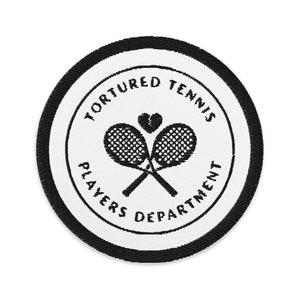 Puede incluir: Parche bordado en blanco y negro con el texto "Tortured Tennis Players Department" y un gráfico de dos raquetas de tenis cruzadas con un corazón en el medio.