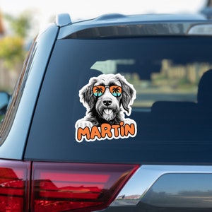Puede incluir: Una ilustración en blanco y negro de un perro con gafas de sol con palmeras reflejadas en las lentes. El perro mira a la cámara y tiene la lengua fuera. El texto "MARTIN" está escrito en naranja debajo del perro.