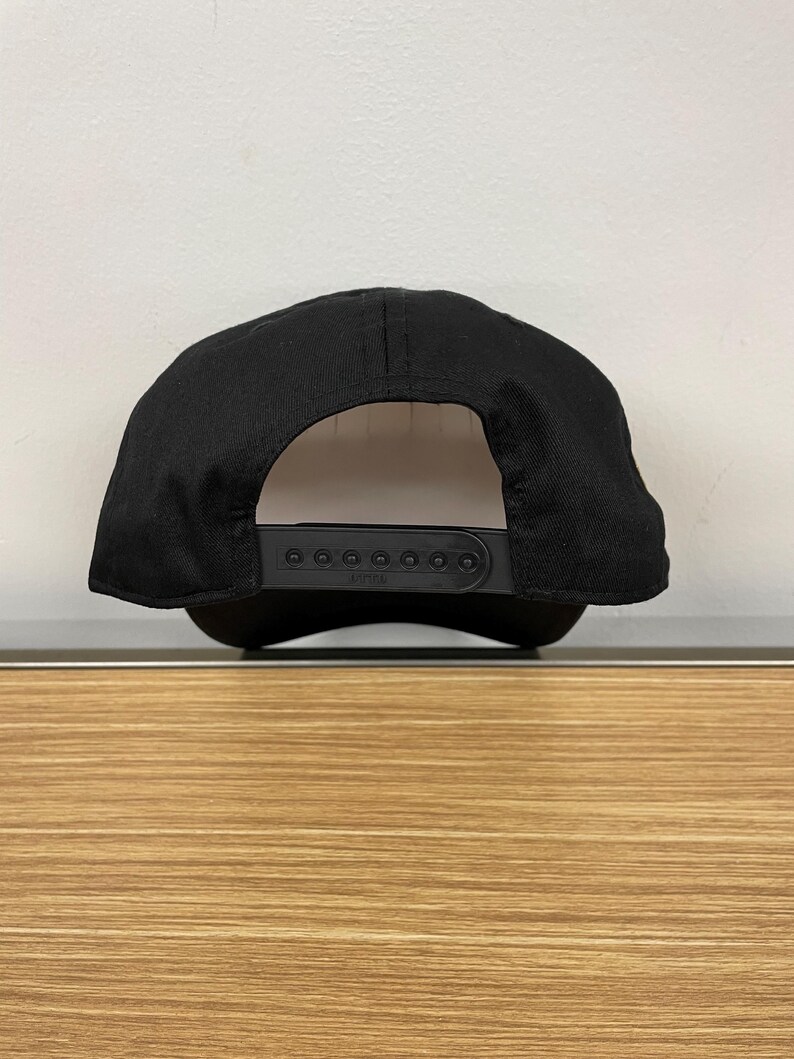 May include: Black baseball cap with a black adjustable strap and a white label that says "ZYNIA".