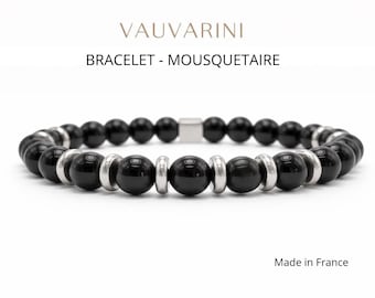 Puede incluir: Pulsera de cuentas negras con detalles plateados. La pulsera presenta cuentas negras brillantes, anillos de metal plateado y un cierre cuadrado. El texto de la imagen dice "BRACELET - MOUSQUETAIRE". Hecho en Francia.