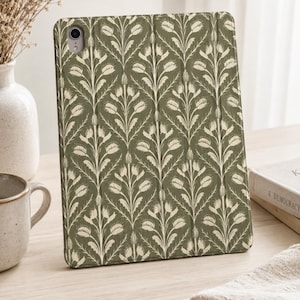 Può includere: Una custodia per tablet con un motivo botanico ripetuto di tulipani e fogliame color crema su uno sfondo verde oliva tenue. La custodia presenta un ritaglio circolare nell'angolo in alto a sinistra per l'obiettivo e un design pieghevole.