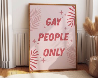 May include: A pink framed print with the text "Gay People Only" in red glitter letters. The print is decorated with pink and red palm leaves and glitter stars.