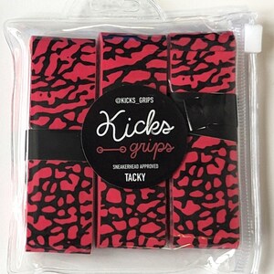 May include: Three rolls of red and black elephant print grip tape packaged in a clear plastic pouch. A circular black label features the text @KICKS_GRIPS, Kicks grips, SNEAKERHEAD APPROVED, and TACKY. The tape is secured with a black paper band.