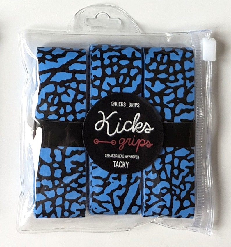 May include: Three rolls of blue and black elephant print grip tape packaged in a clear plastic bag. A circular black label on the front features the text @KICKS_GRIPS, Kicks grips, SNEAKERHEAD APPROVED, and TACKY in white and red lettering.