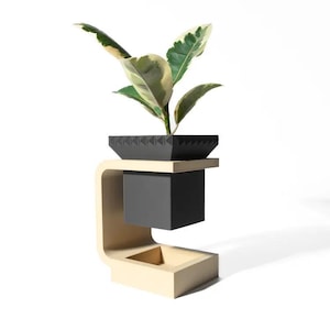 May include: A black planter with a geometric pattern sits on a wooden stand. The planter is filled with a green and white variegated plant.